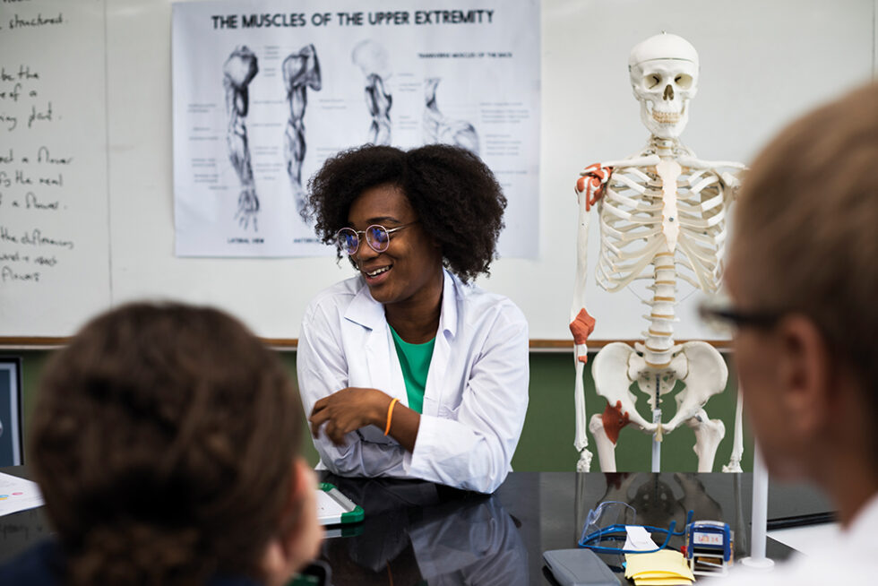 biology teacher teaching biology to diverse group of high school