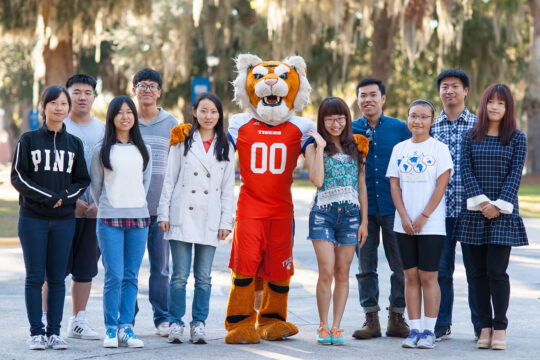 international students smiling with mascot