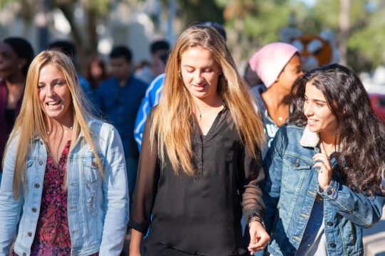 students walking in sun on campus life